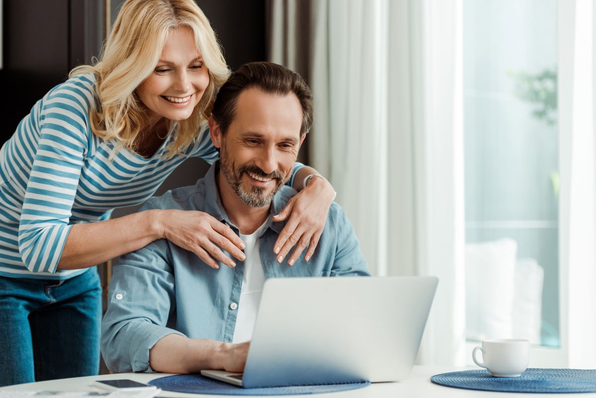 Mature couple looking at laptop smiling