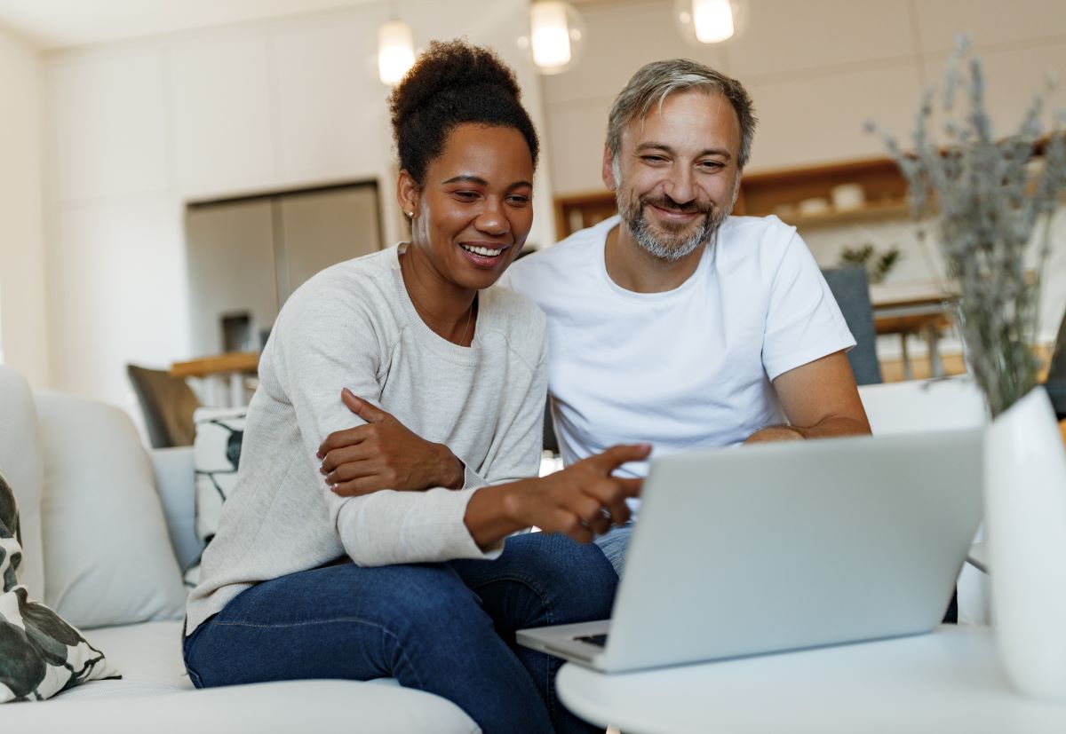 Couple reviewing documents sitting on a couch